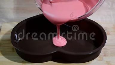 将粉红色的慕斯倒入心形模具中。在厨房做慕斯蛋糕的糖果商